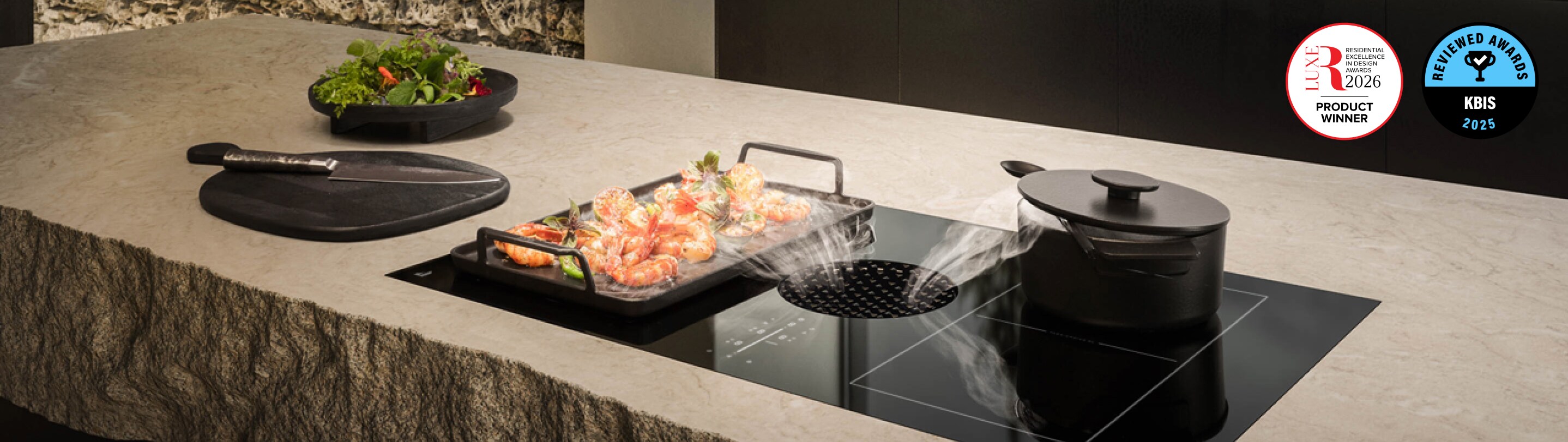 A JennAir Electric Downdraft Cooktop drawing steam from food cooking in a pan.