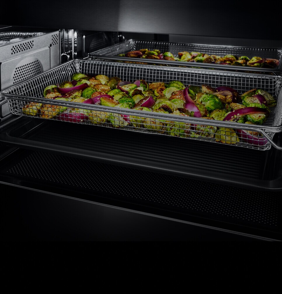 A variety of cut vegetables in an air fry tray.