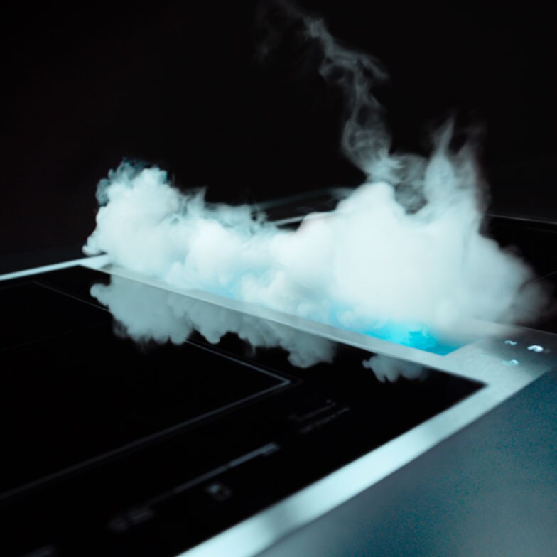 Smoke and steam being pulled into a JennAir downdraft ventilation system. 