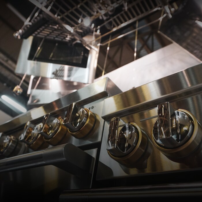 Different elements of a JennAir range hanging from the ceiling apart of a installation piece at a showroom. 