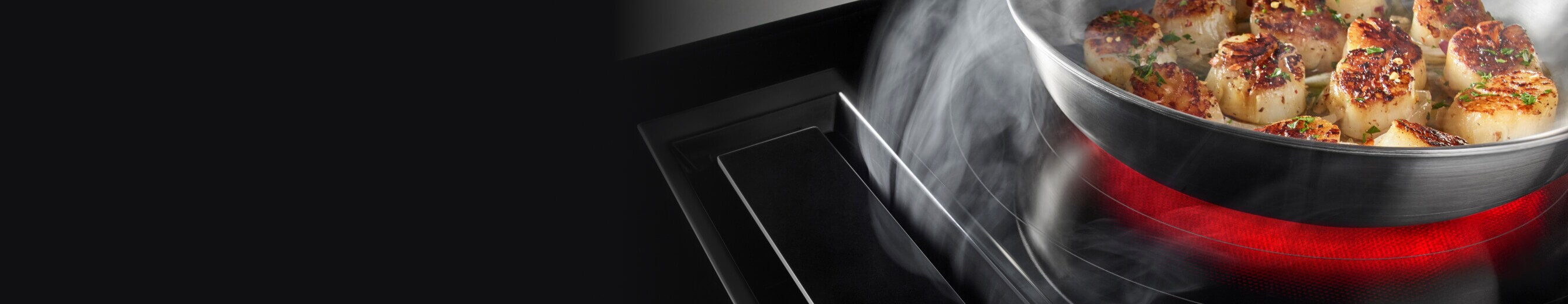 A JennAir Electric Downdraft Cooktop drawing steam from food cooking in a pan.