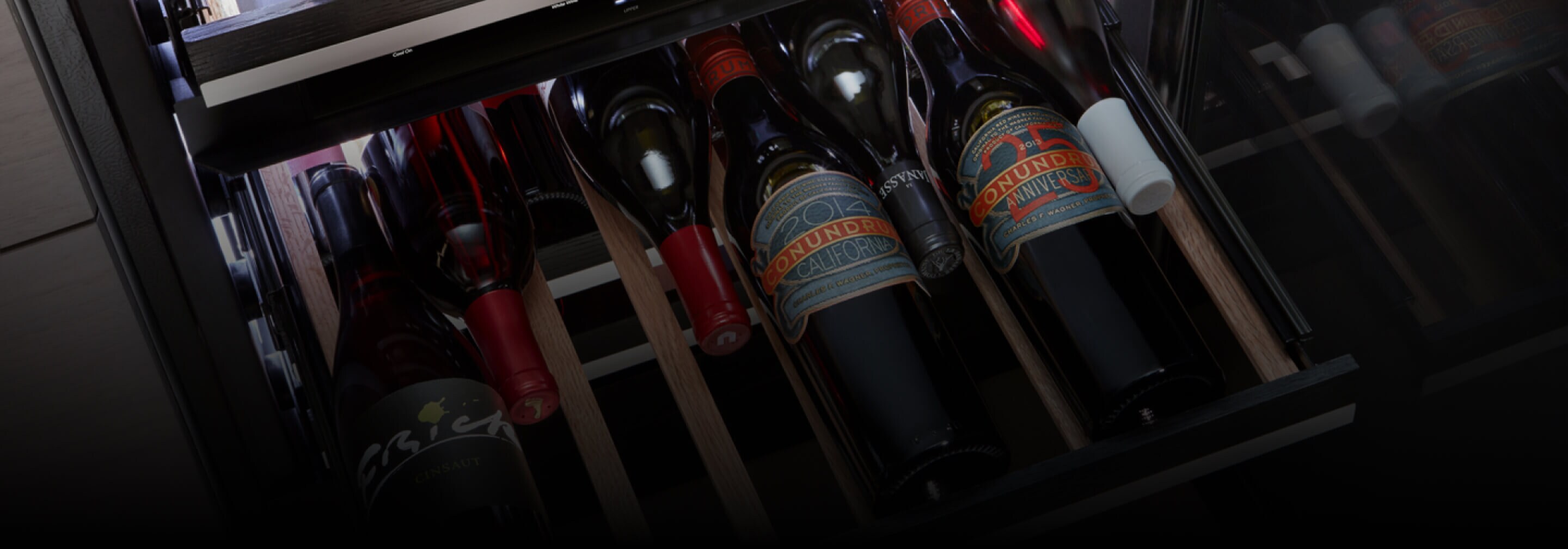 Wine bottles nestled in the beechwood tines in the lower zone of the beverage center.