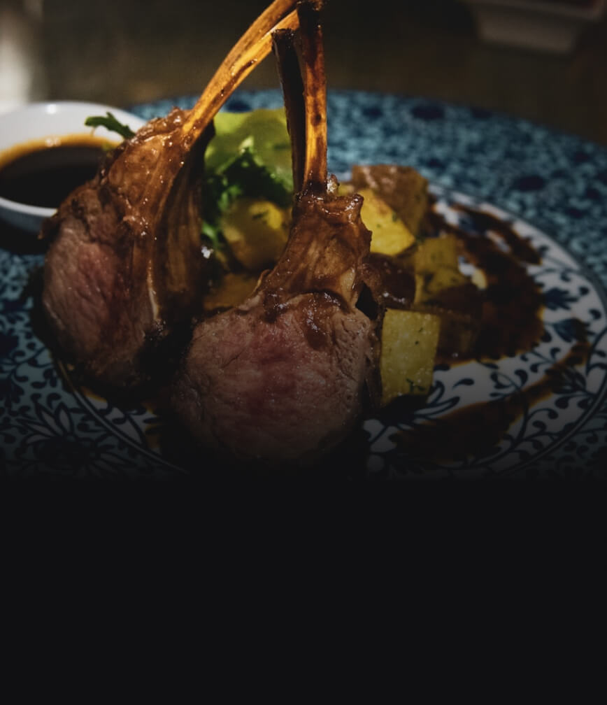 Lamb chops arranged on a blue plate.
