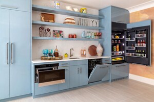 A bright kitchen with blue cabinets, outfitted with JennAir® appliances 