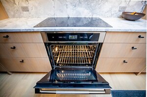 An open JennAir® wall oven installed below an induction cooktop