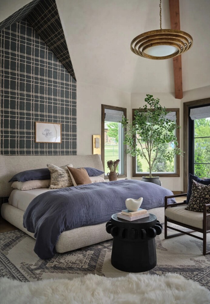 A bedroom with a partially wallpapered wall