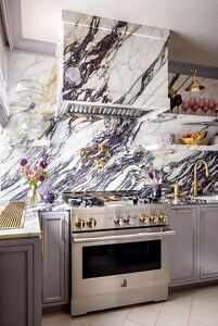 A close up on a JennAir® range in a marble kitchen.