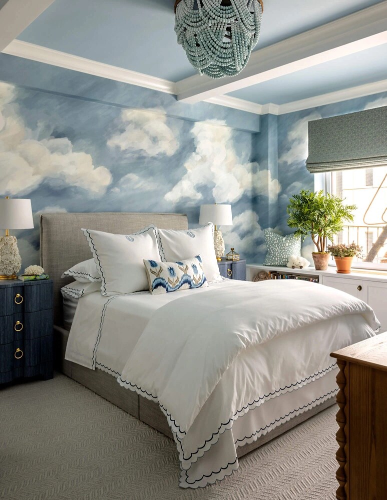 A bedroom with a cloud and sky motif.