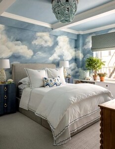 A bedroom with a cloud and sky motif.