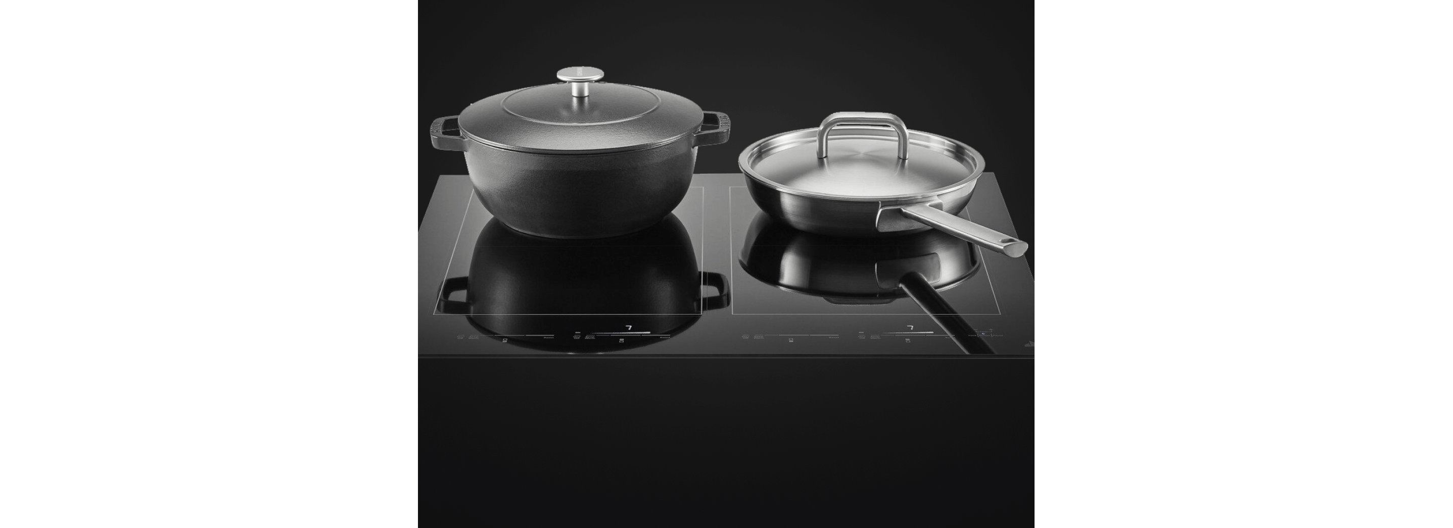 A pot and pan sitting on the edge-to-edge glass cooktop.