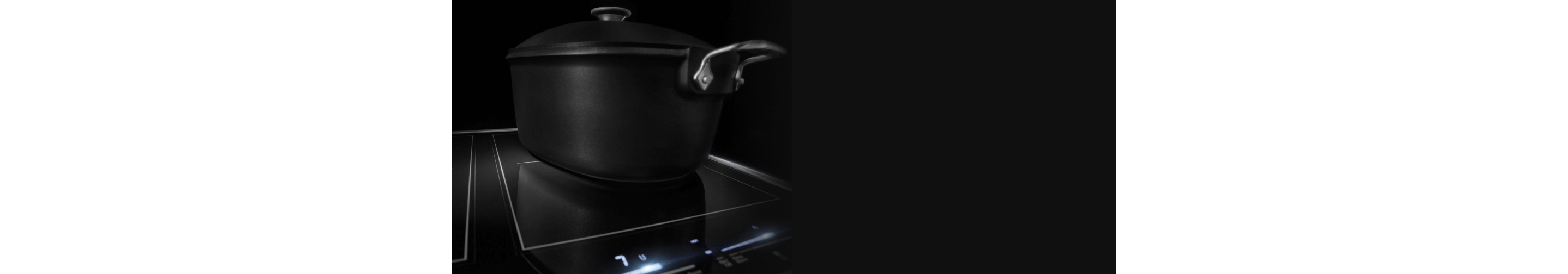 Closeup of a black pot on the glass induction cooktop.