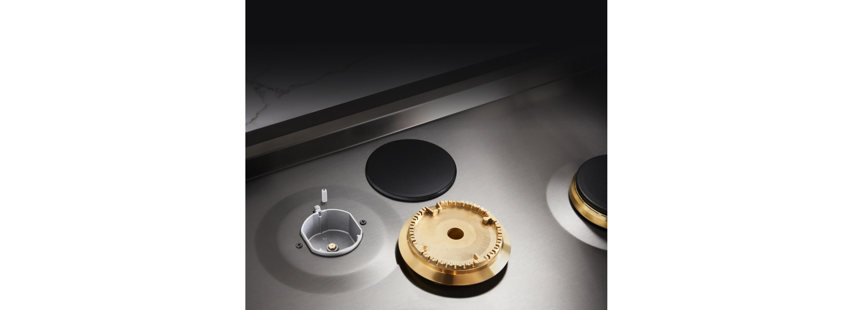 Closeup of the brass burner and cap removed from the cooktop.