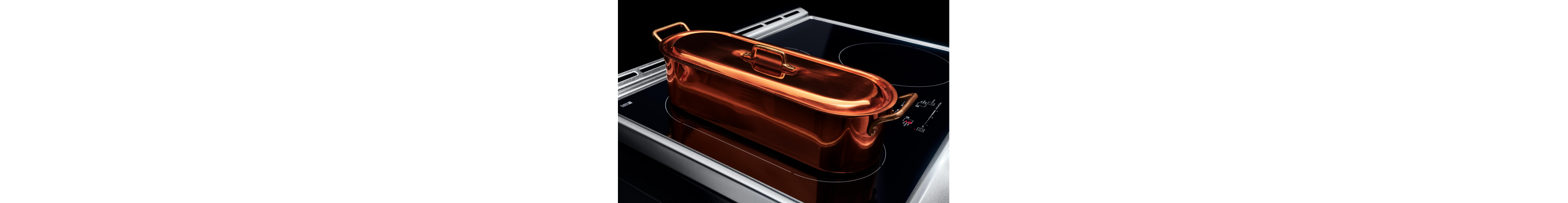 A copper frying pan on an induction cooktop bridge element.