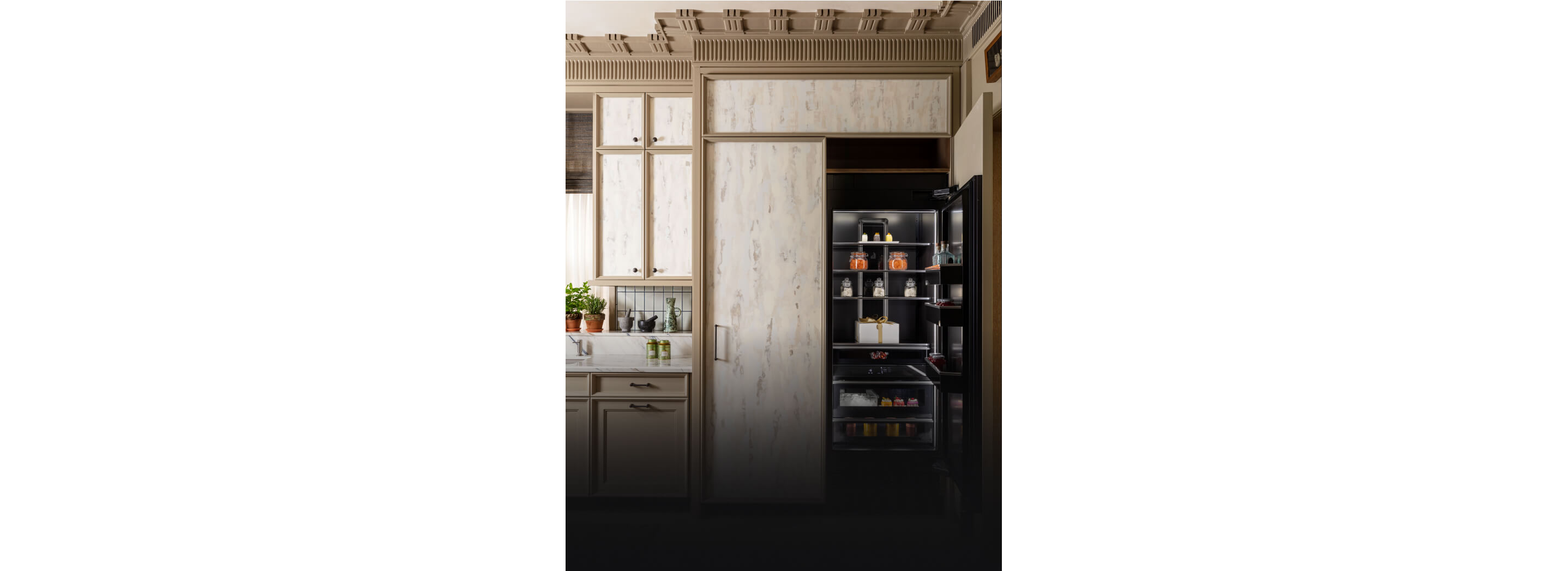 A pair of panel-ready column refrigerators, one open, fitted with custom milled cabinetry.