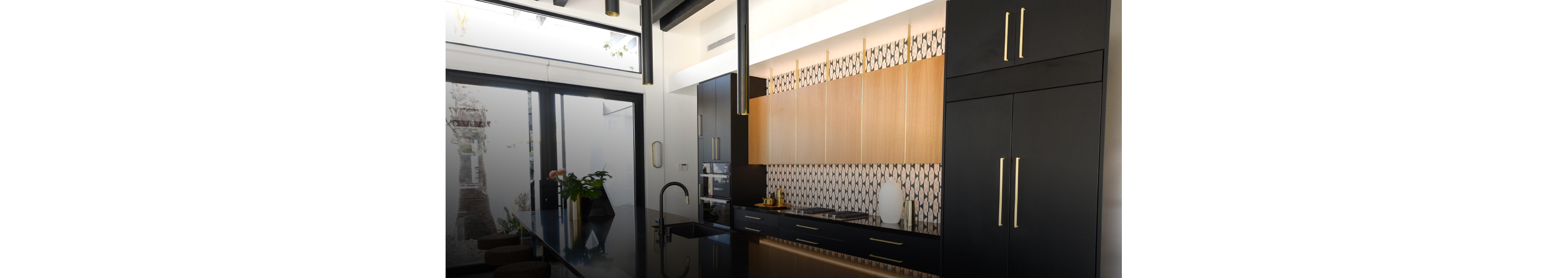 A modern kitchen filled with built-in refrigerators fitted with custom panels.