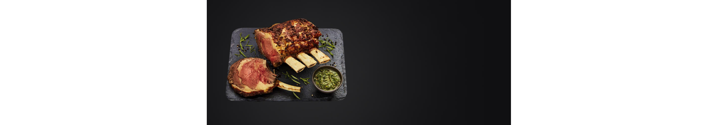 A Crown Rack of Lamb on a slate serving plate.