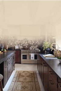 A modern kitchen with maroon cabinetry and JennAir® appliances. 