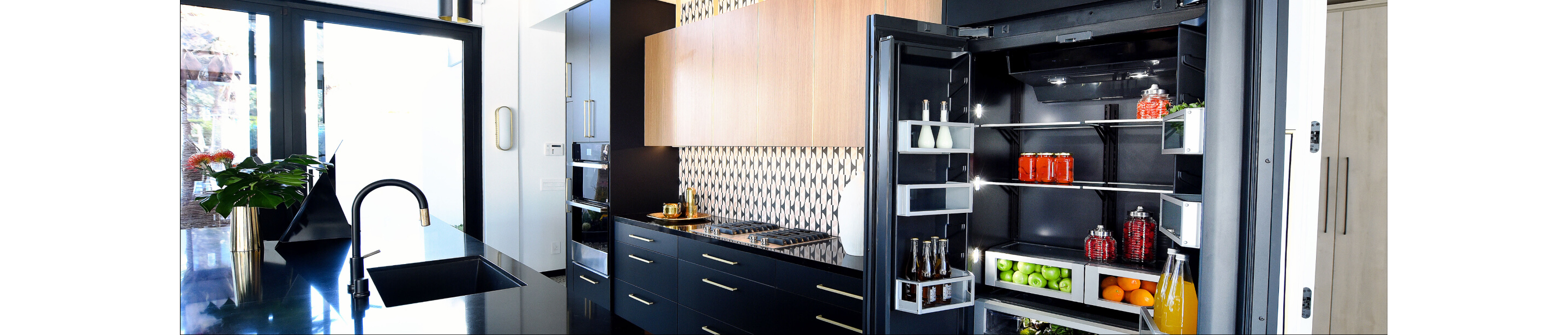 An open JennAir refrigerator in a luxe kitchen.