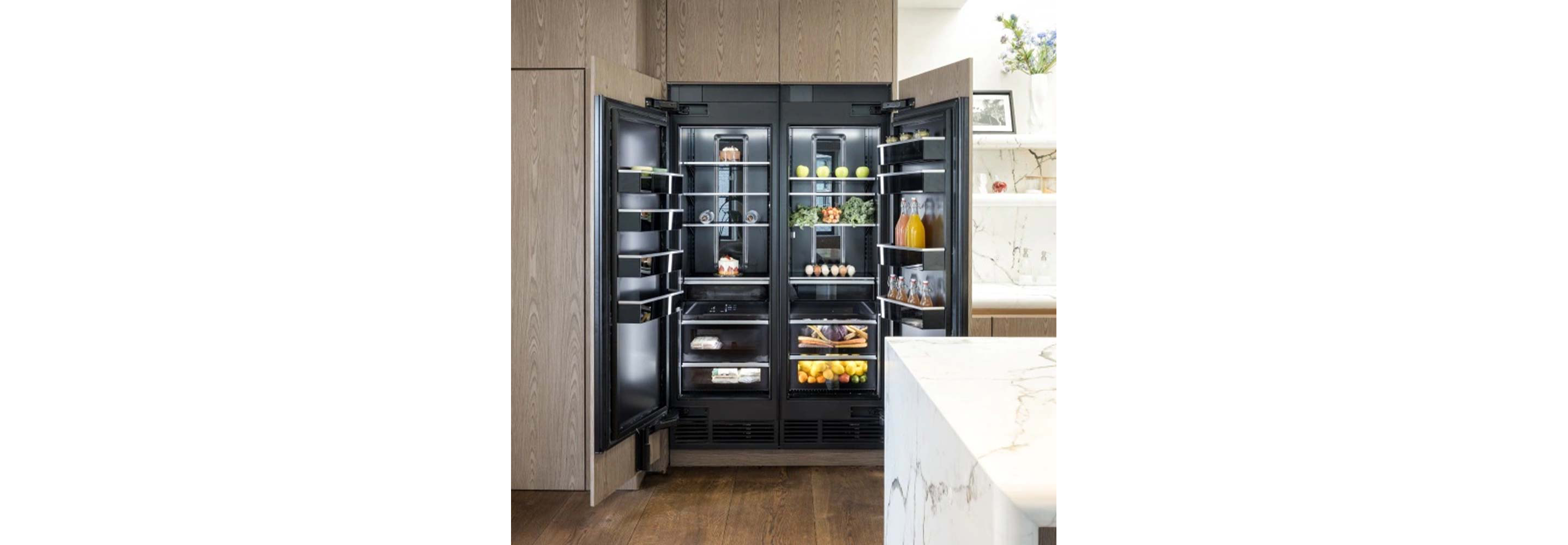 An open JennAir refrigerator in a bright, modern kitchen. 