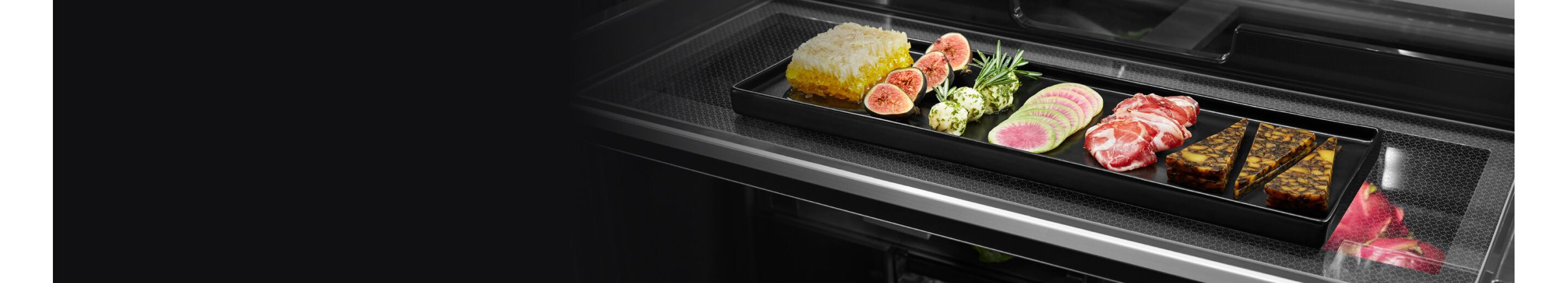 A charcuterie tray on a full-length shelf in a freestanding refrigerator.