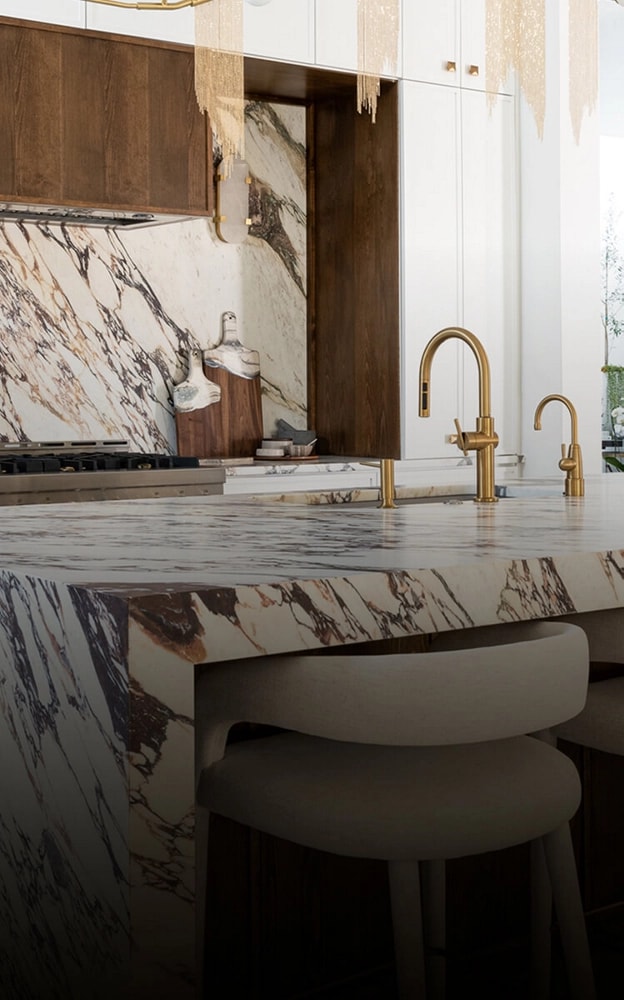 A modern ktichen, with bold marble countertops and JennAir appliances.