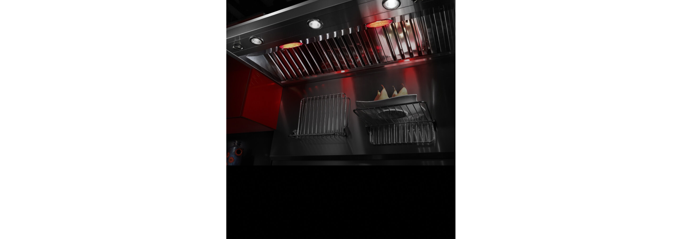 Warming lamps on a wall-mount ventilation hood.